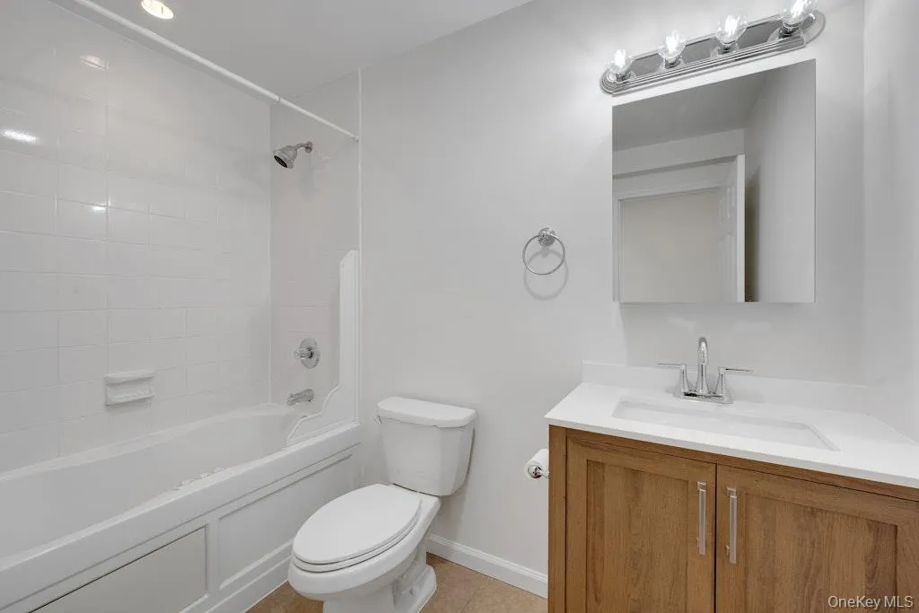 Full bathroom with vanity, shower / washtub combination, and light tile patterned floors Full bathroom with vanity, shower / washtub combination, and light tile patterned floors