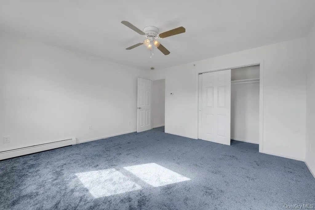 Unfurnished bedroom featuring carpet, ceiling fan, and a closet Unfurnished bedroom featuring carpet, ceiling fan, and a closet
