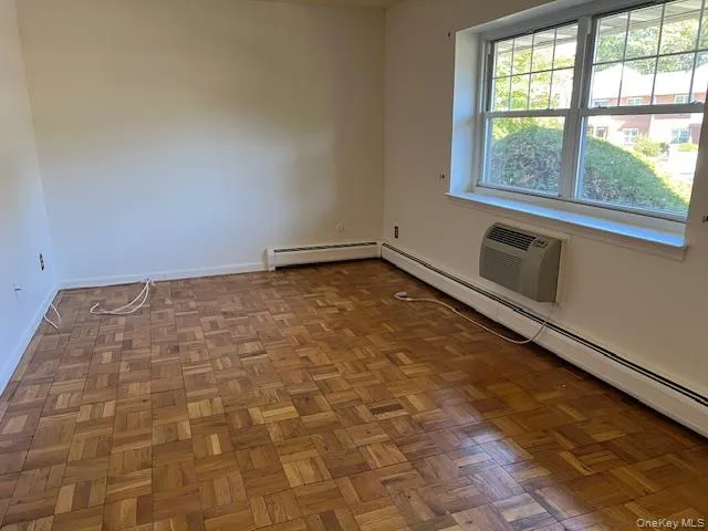 Spare room featuring a baseboard heating unit and a wall mounted AC Spare room featuring a baseboard heating unit and a wall mounted AC