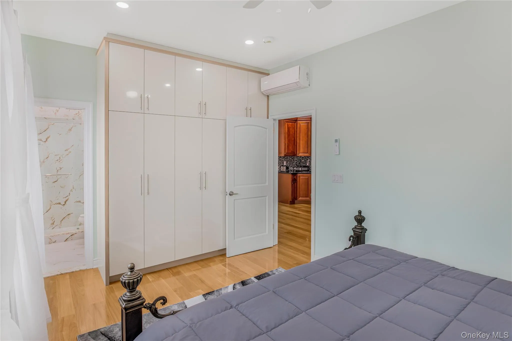 Main bedroom featuring light wood-type flooring, a custom-made closet, a ceiling fan, recessed lighting, and an AC wall unit Main bedroom featuring light wood-type flooring, a custom-made closet, a ceiling fan, recessed lighting, and an AC wall unit