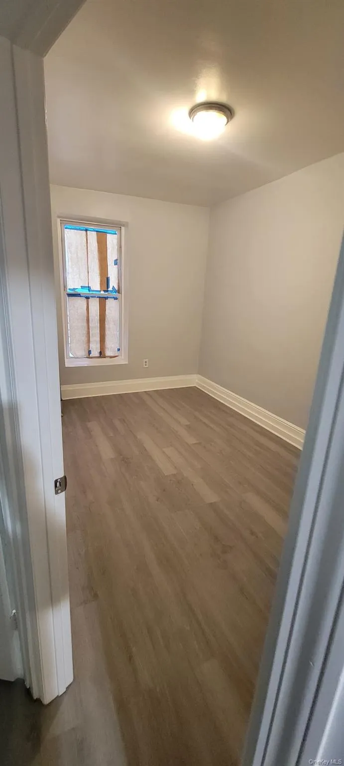 Empty room with wood finished floors and baseboards Empty room with wood finished floors and baseboards