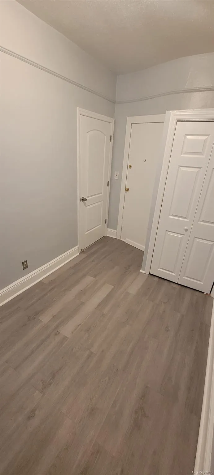 Unfurnished room featuring wood finished floors and a textured ceiling Unfurnished room featuring wood finished floors and a textured ceiling