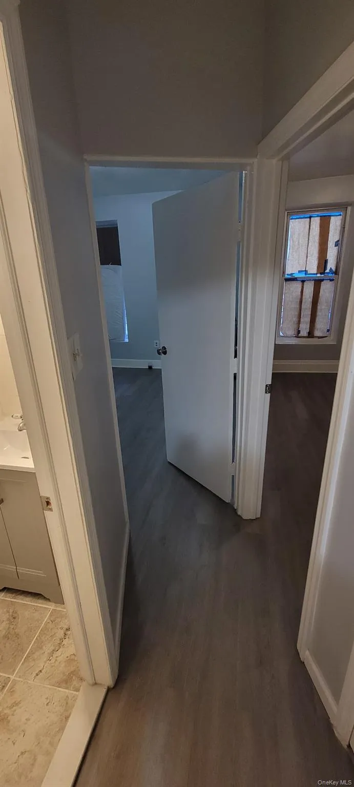 Hallway featuring baseboards and light wood-type flooring Hallway featuring baseboards and light wood-type flooring