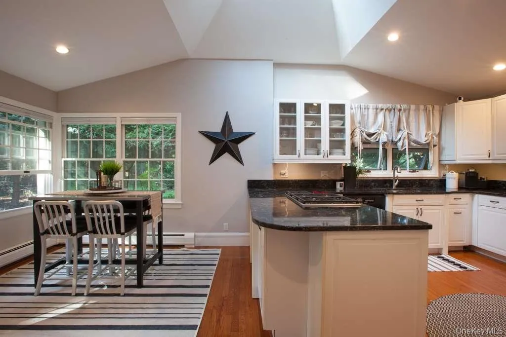 Kitchen with a peninsula, dark stone countertops, light wood-type flooring, healthy amount of natural light, and recessed lighting Kitchen with a peninsula, dark stone countertops, light wood-type flooring, healthy amount of natural light, and recessed lighting