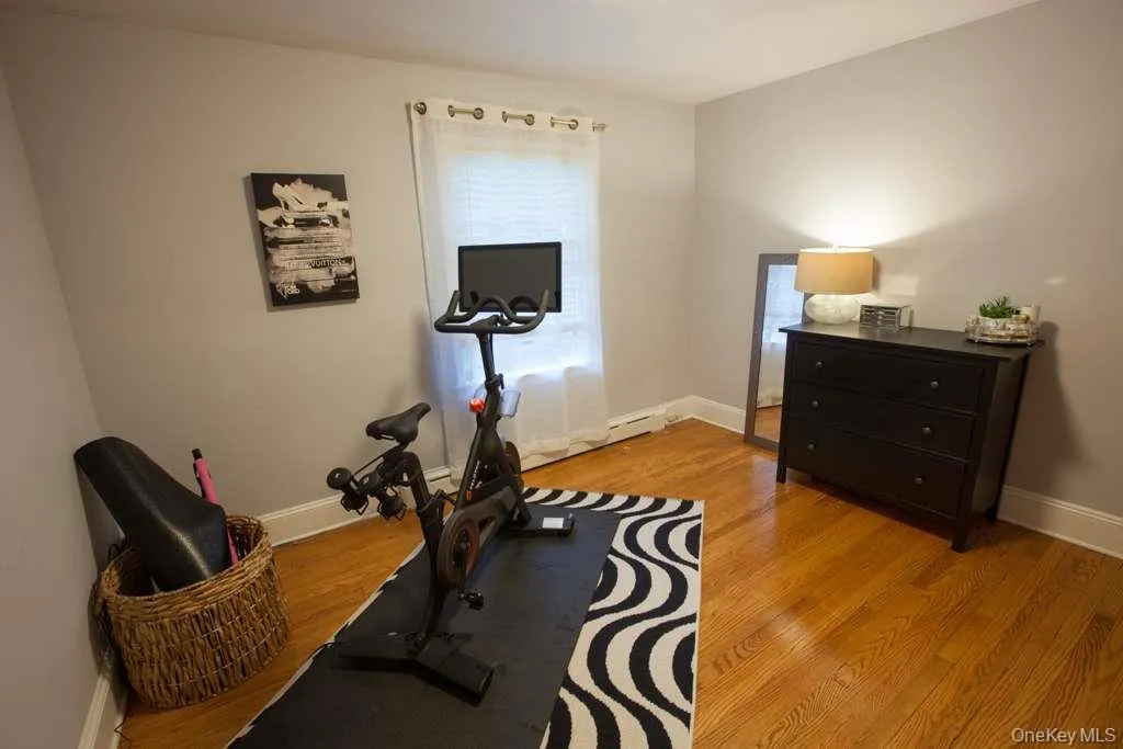 Exercise area with baseboards and light wood-style floors Exercise area with baseboards and light wood-style floors