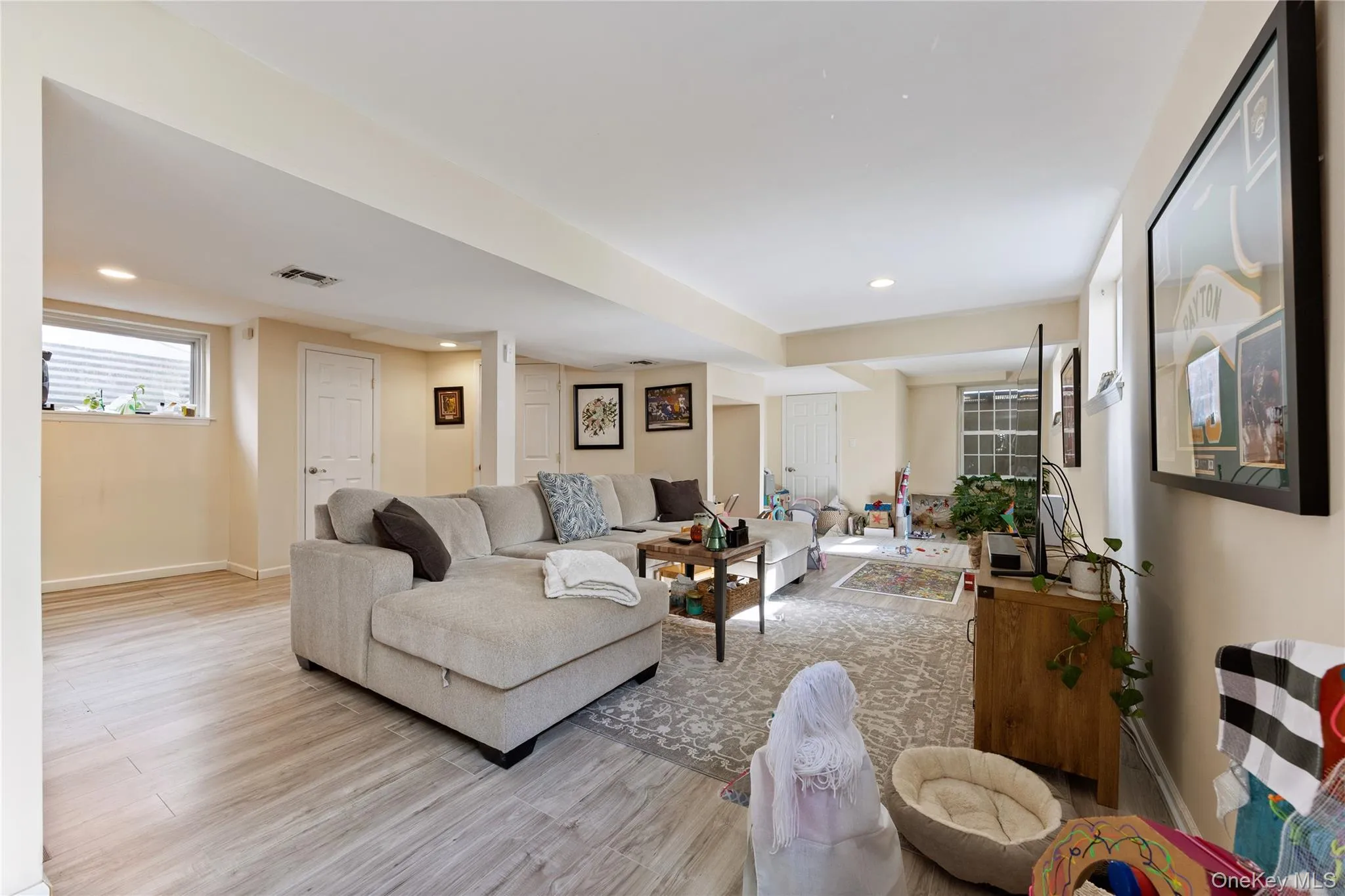 Living area with light wood-style flooring and recessed lighting Living area with light wood-style flooring and recessed lighting