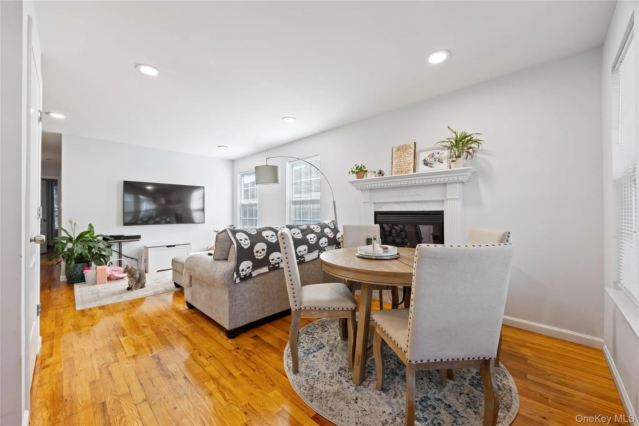 Dining space with a glass covered fireplace, light wood-type flooring, and recessed lighting Dining space with a glass covered fireplace, light wood-type flooring, and recessed lighting