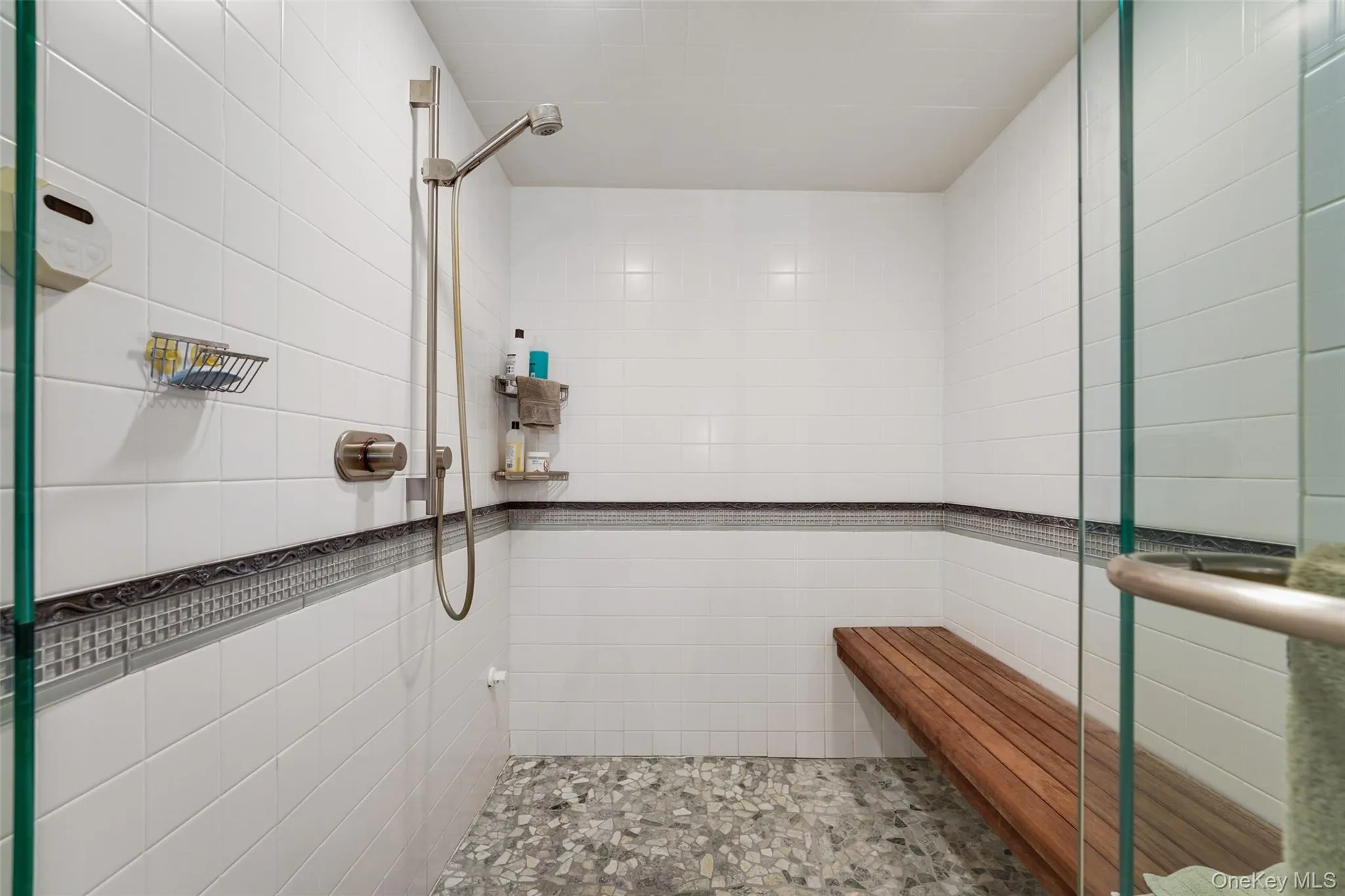 Bathroom featuring tile walls and tiled shower Bathroom featuring tile walls and tiled shower