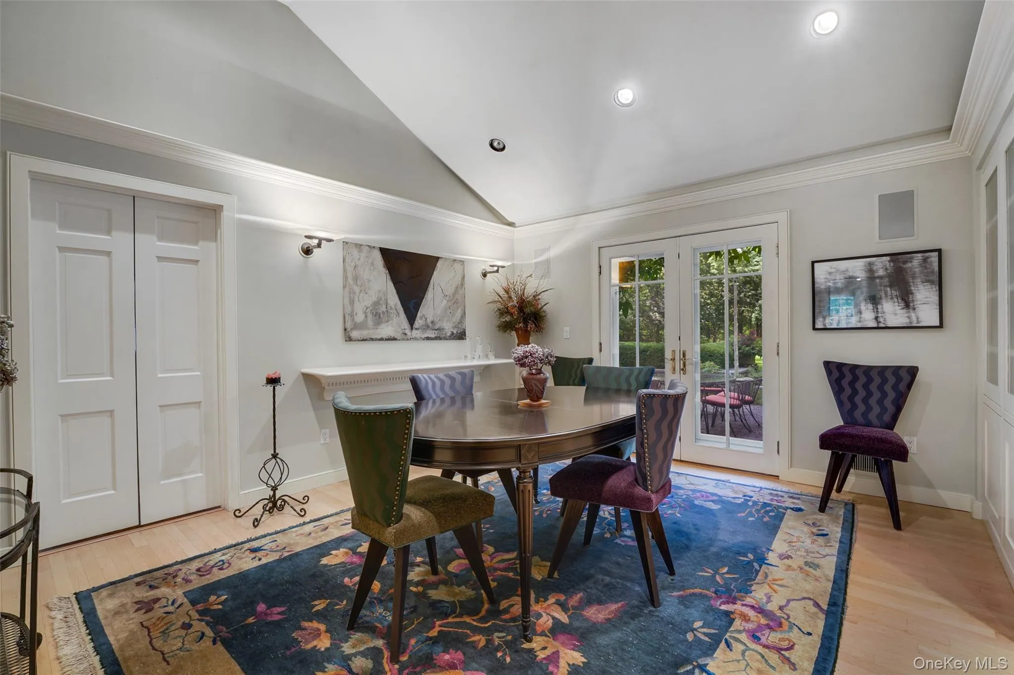 Dining space featuring wood finished floors, french doors, crown molding, baseboards, and vaulted ceiling Dining space featuring wood finished floors, french doors, crown molding, baseboards, and vaulted ceiling