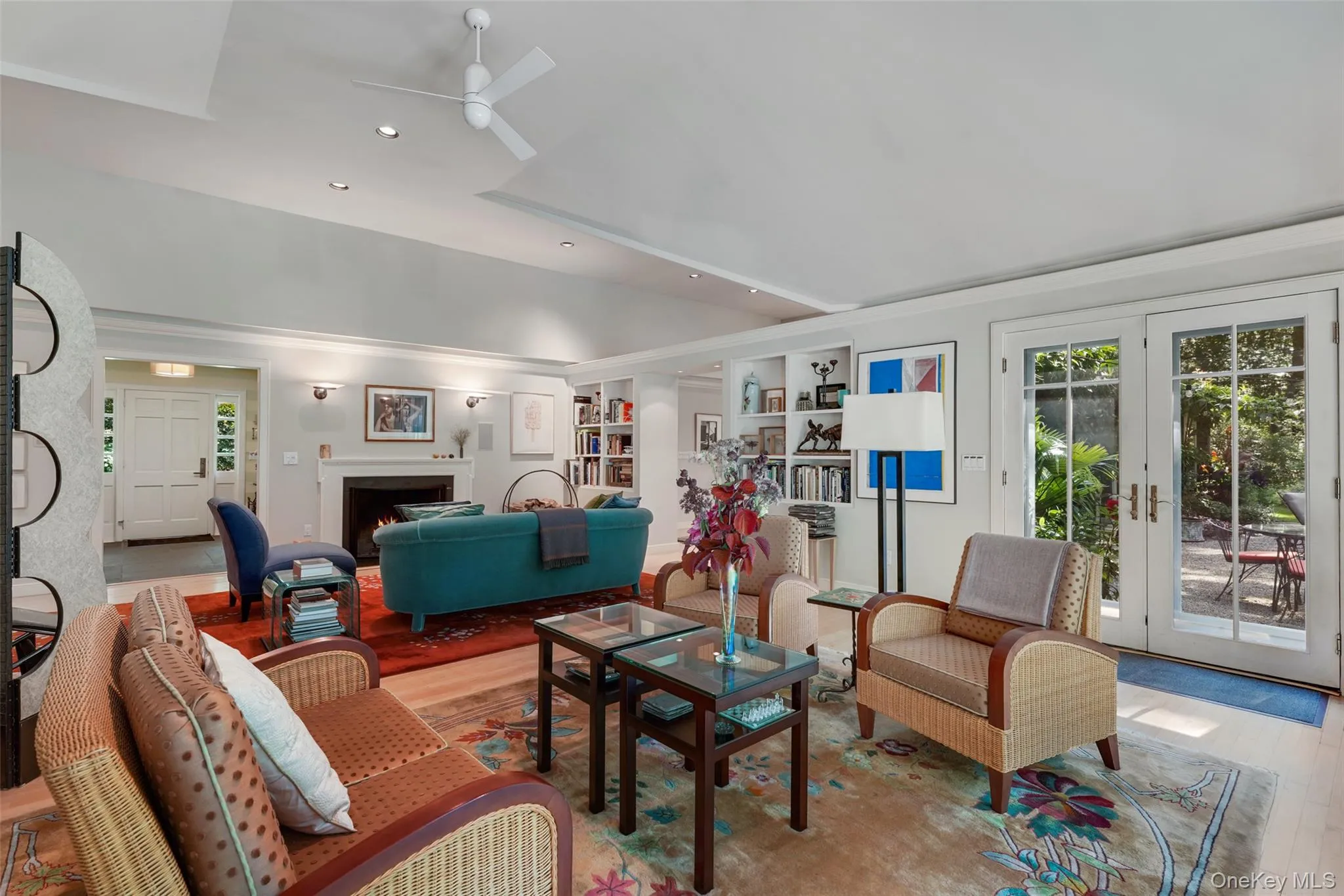Living area with built in shelves, wood finished floors, recessed lighting, a lit fireplace, and ceiling fan Living area with built in shelves, wood finished floors, recessed lighting, a lit fireplace, and ceiling fan