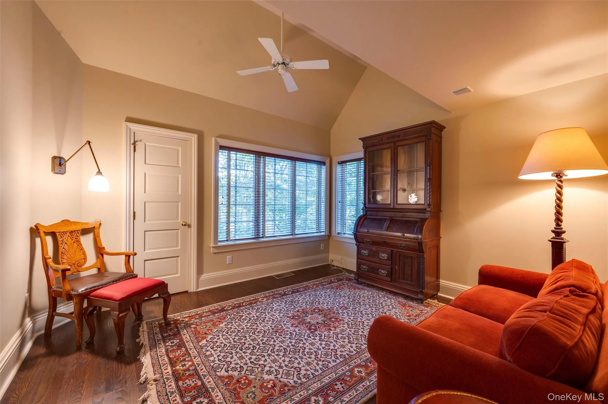 Living area featuring dark wood-style floors, ceiling fan, and high vaulted ceiling Living area featuring dark wood-style floors, ceiling fan, and high vaulted ceiling