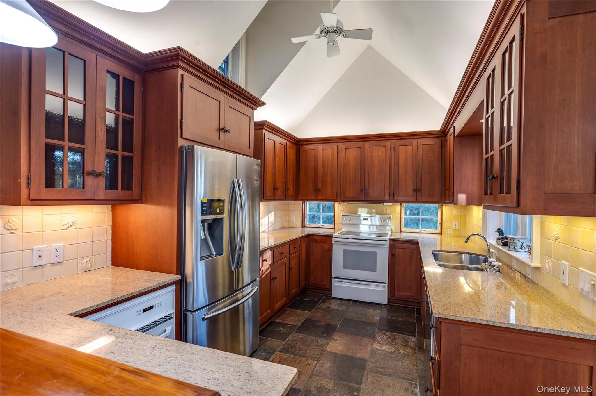 Kitchen featuring glass insert cabinets, white appliances, backsplash, and high vaulted ceiling Kitchen featuring glass insert cabinets, white appliances, backsplash, and high vaulted ceiling