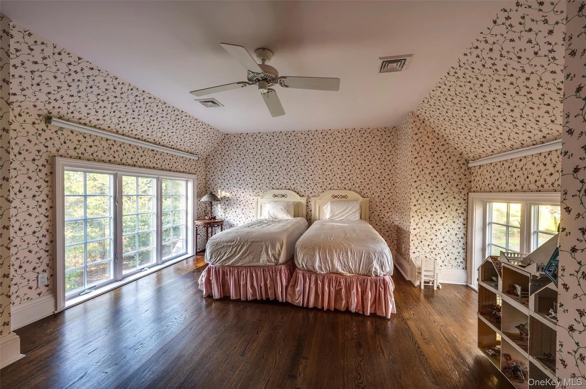 Bedroom with wood finished floors, wallpapered walls, and ceiling fan Bedroom with wood finished floors, wallpapered walls, and ceiling fan