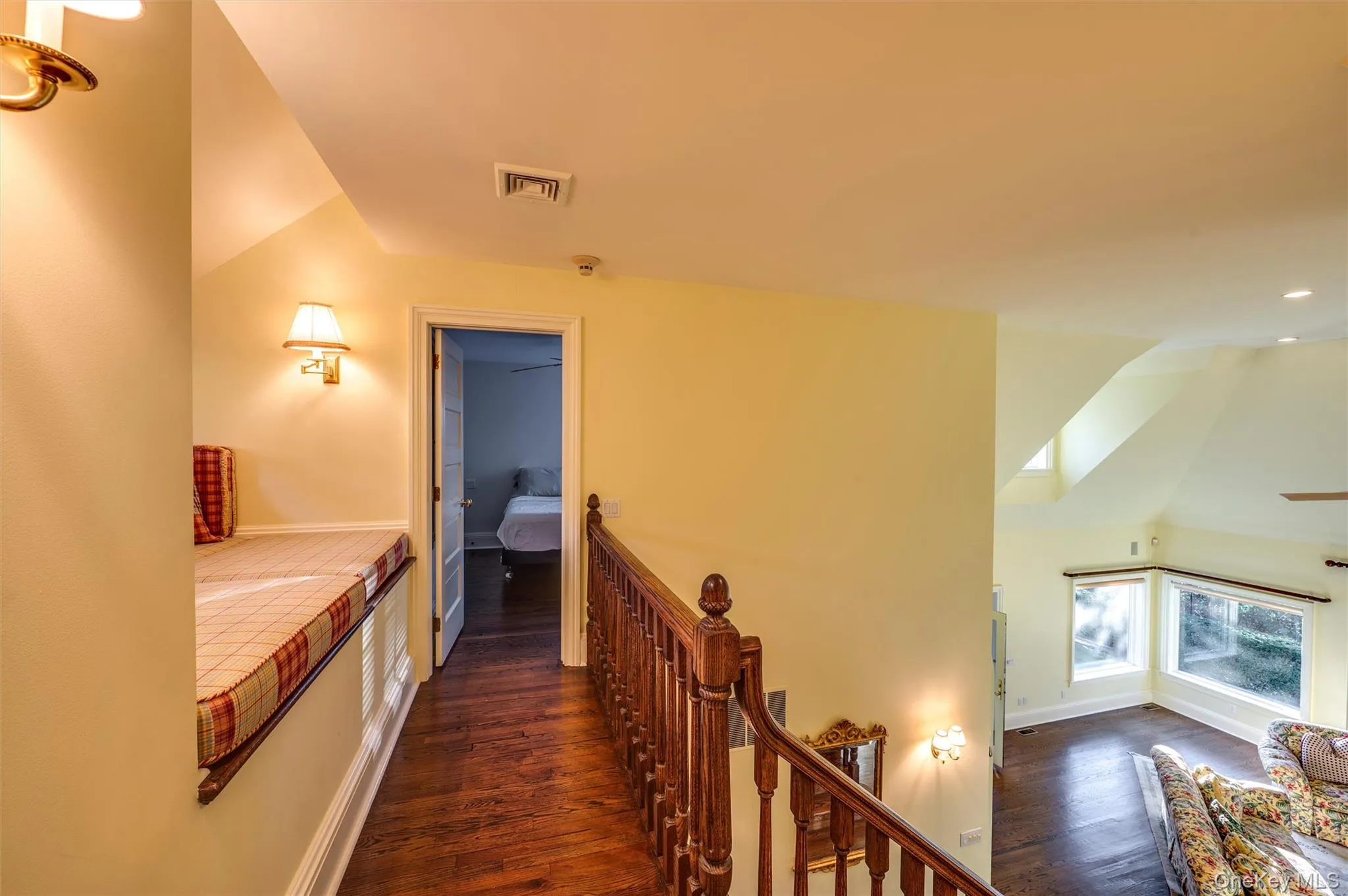 Corridor with vaulted ceiling, dark wood-style floors, and an upstairs landing Corridor with vaulted ceiling, dark wood-style floors, and an upstairs landing