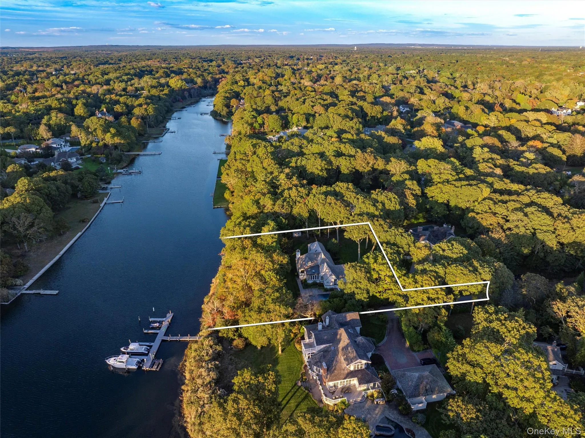 Aerial view of property and surrounding area featuring a large body of water and property parcel outlined Aerial view of property and surrounding area featuring a large body of water and property parcel outlined