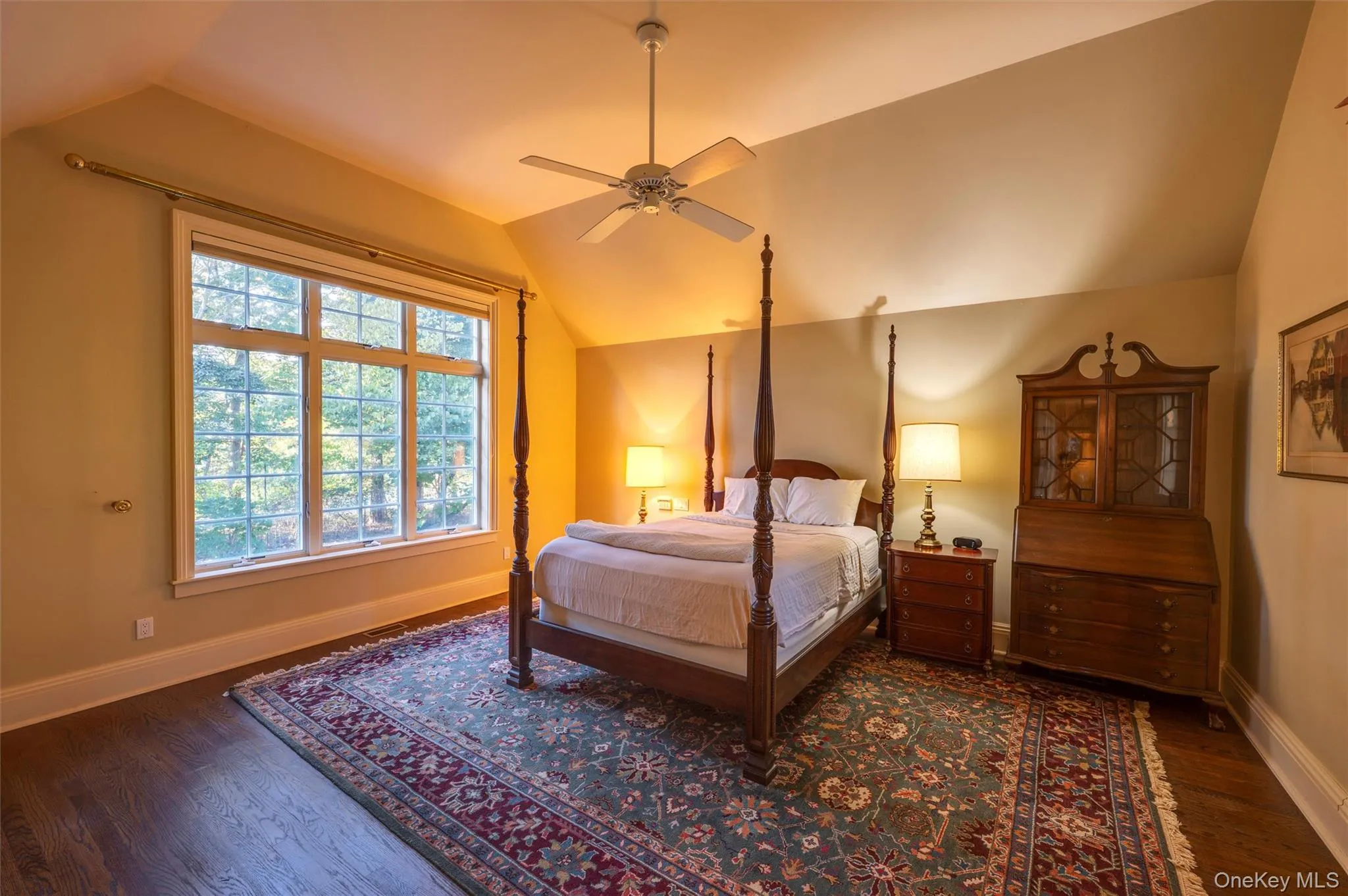 Bedroom featuring vaulted ceiling, dark wood-type flooring, and a ceiling fan Bedroom featuring vaulted ceiling, dark wood-type flooring, and a ceiling fan