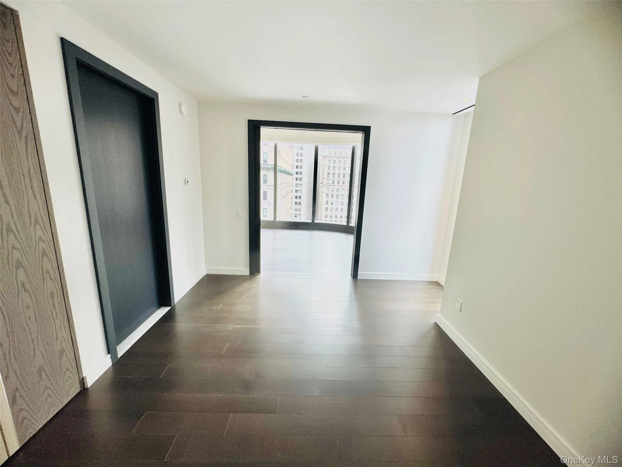 Corridor featuring baseboards and dark wood-type flooring Corridor featuring baseboards and dark wood-type flooring