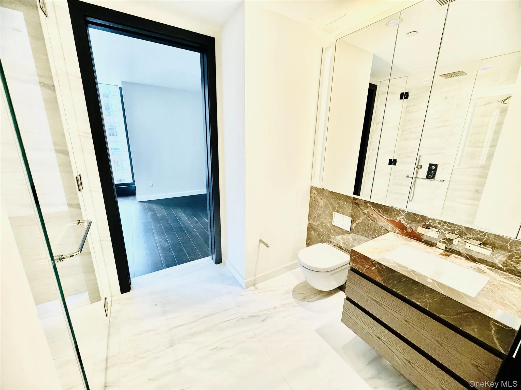 Full bathroom featuring a marble finish shower, marble finish flooring, vanity, and decorative backsplash Full bathroom featuring a marble finish shower, marble finish flooring, vanity, and decorative backsplash