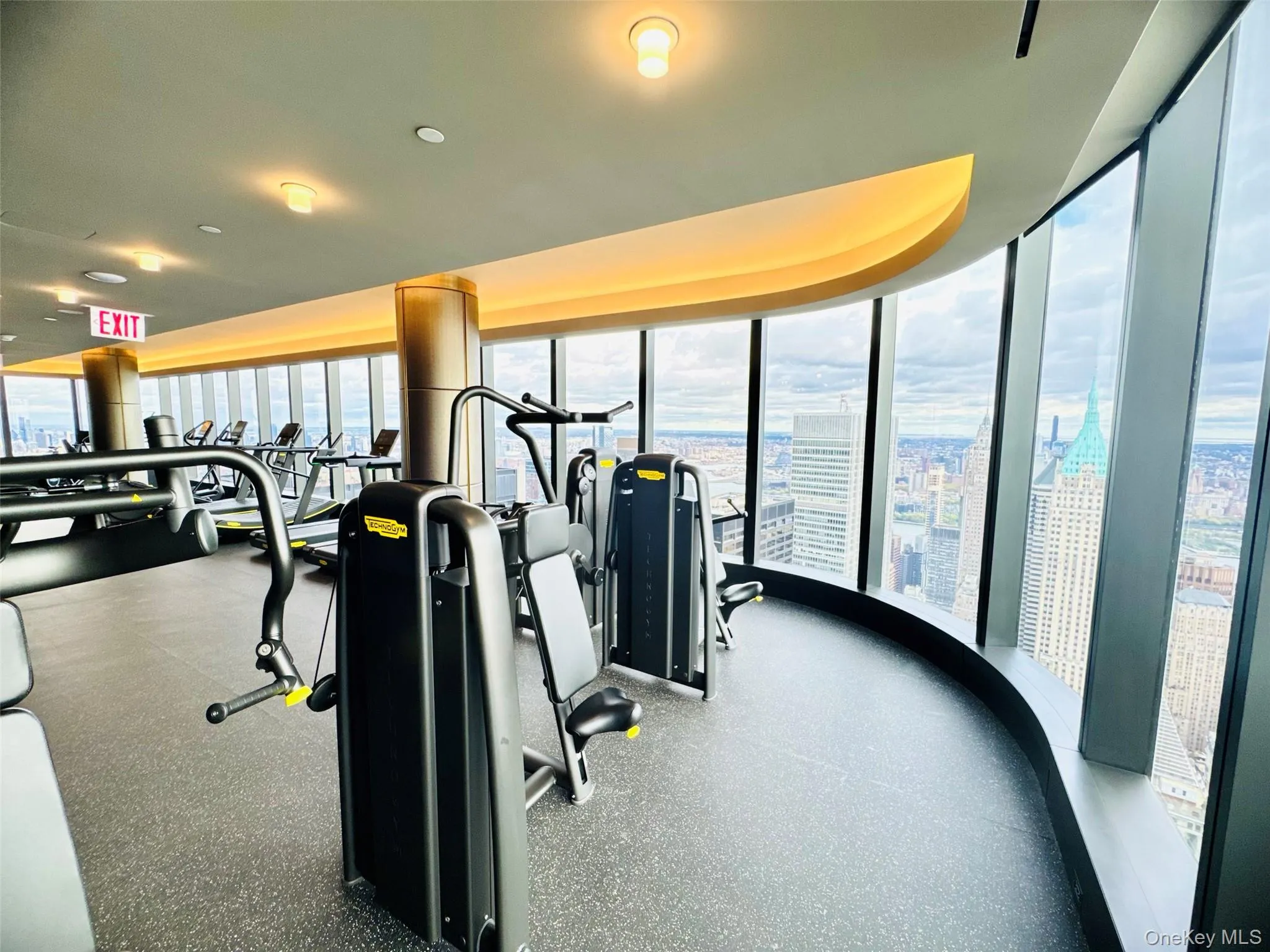 Exercise room featuring floor to ceiling windows, a city view, and recessed lighting Exercise room featuring floor to ceiling windows, a city view, and recessed lighting