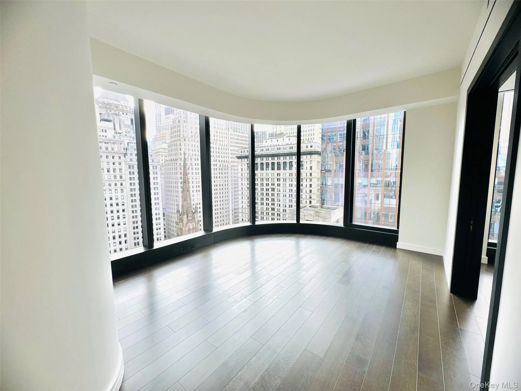 Spare room with a view of city and wood finished floors Spare room with a view of city and wood finished floors