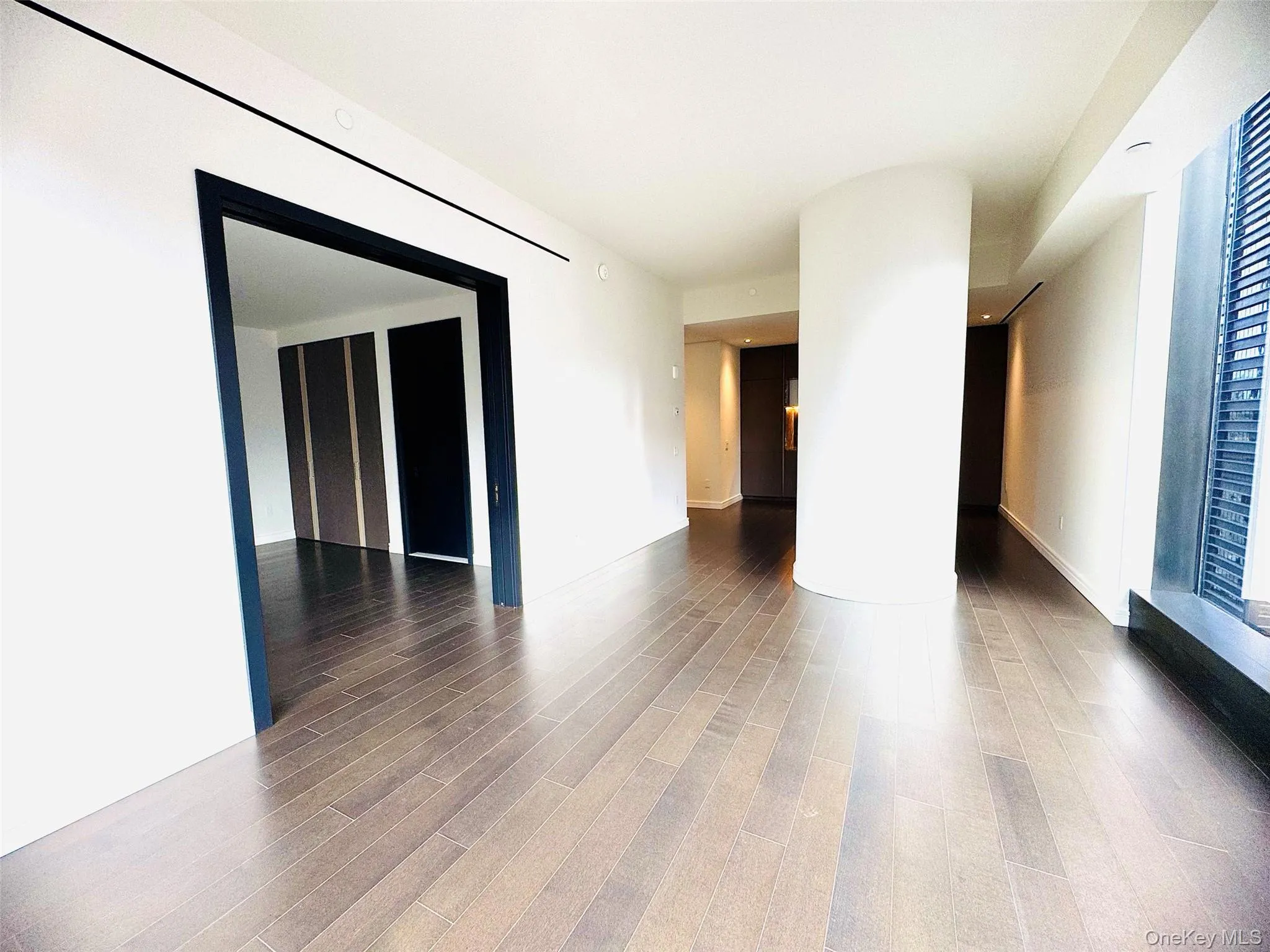Empty room featuring dark wood-type flooring and baseboards Empty room featuring dark wood-type flooring and baseboards