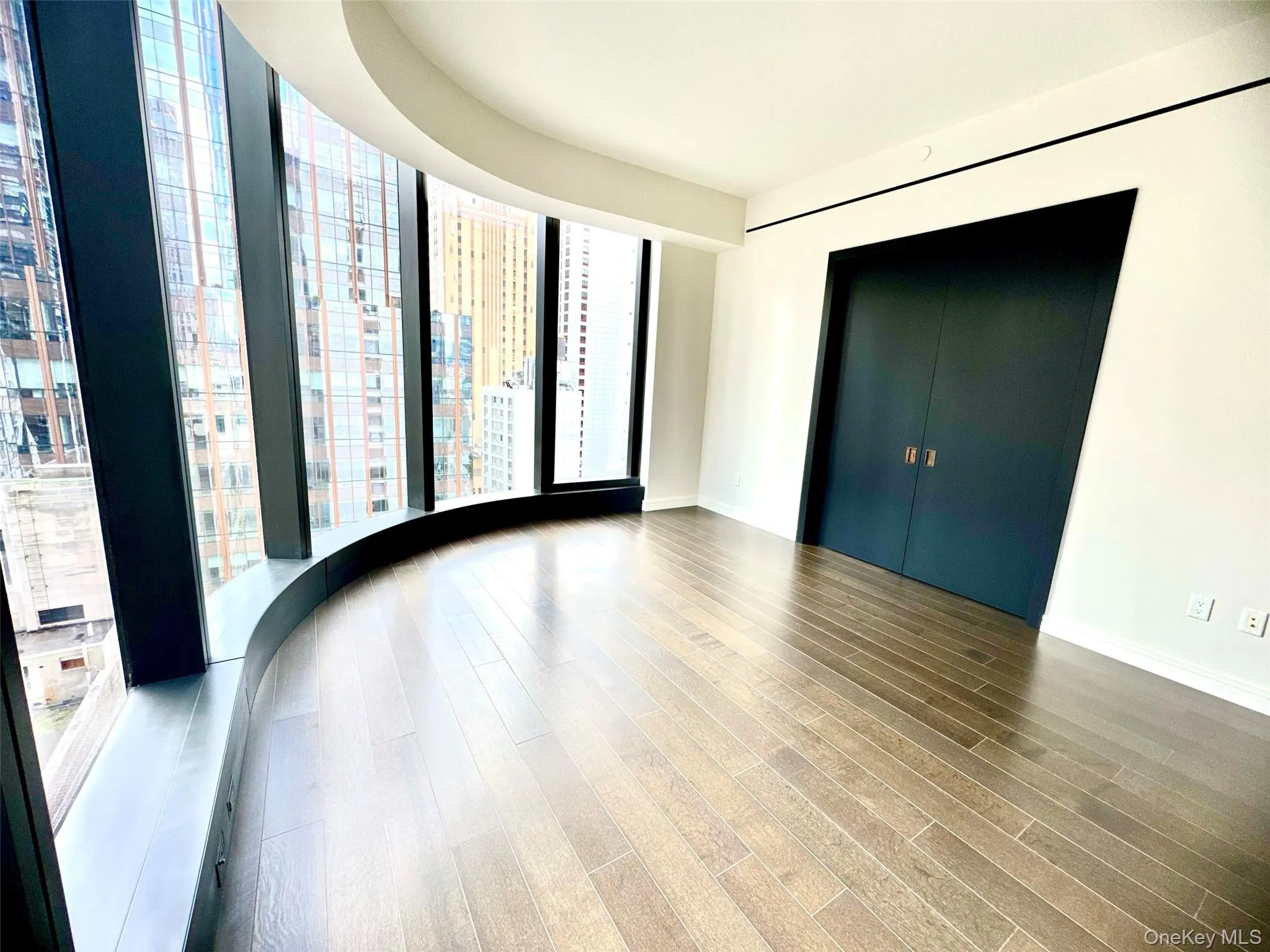 Unfurnished room featuring floor to ceiling windows and wood finished floors Unfurnished room featuring floor to ceiling windows and wood finished floors