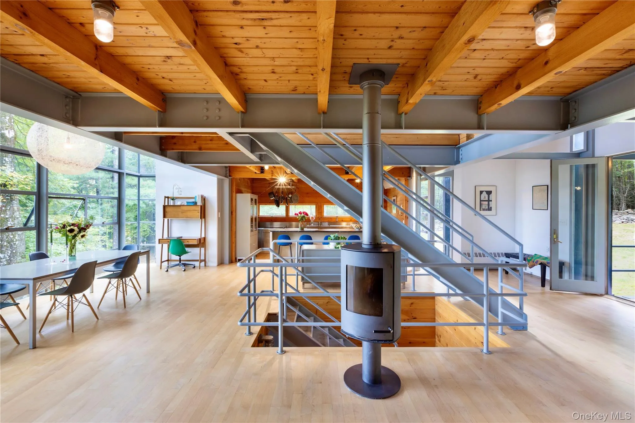 Staircase featuring wood finished floors, expansive windows, a wood ceiling with exposed beams, and a chandelier Staircase featuring wood finished floors, expansive windows, a wood ceiling with exposed beams, and a chandelier
