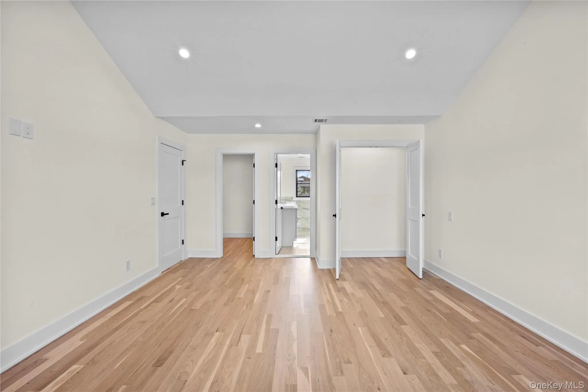 Unfurnished bedroom featuring light wood finished floors, recessed lighting, and connected bathroom Unfurnished bedroom featuring light wood finished floors, recessed lighting, and connected bathroom