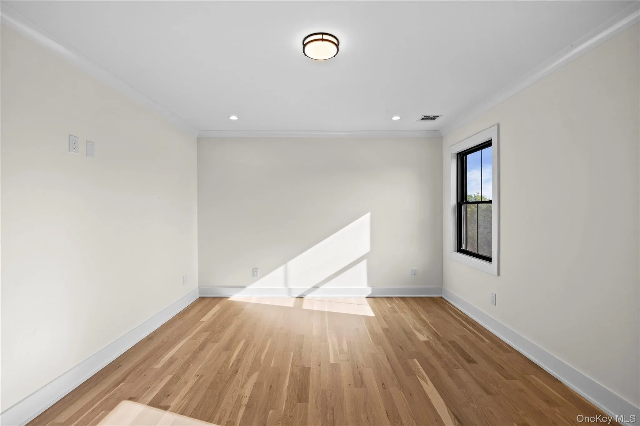 Unfurnished room with ornamental molding, light wood-style flooring, and recessed lighting Unfurnished room with ornamental molding, light wood-style flooring, and recessed lighting