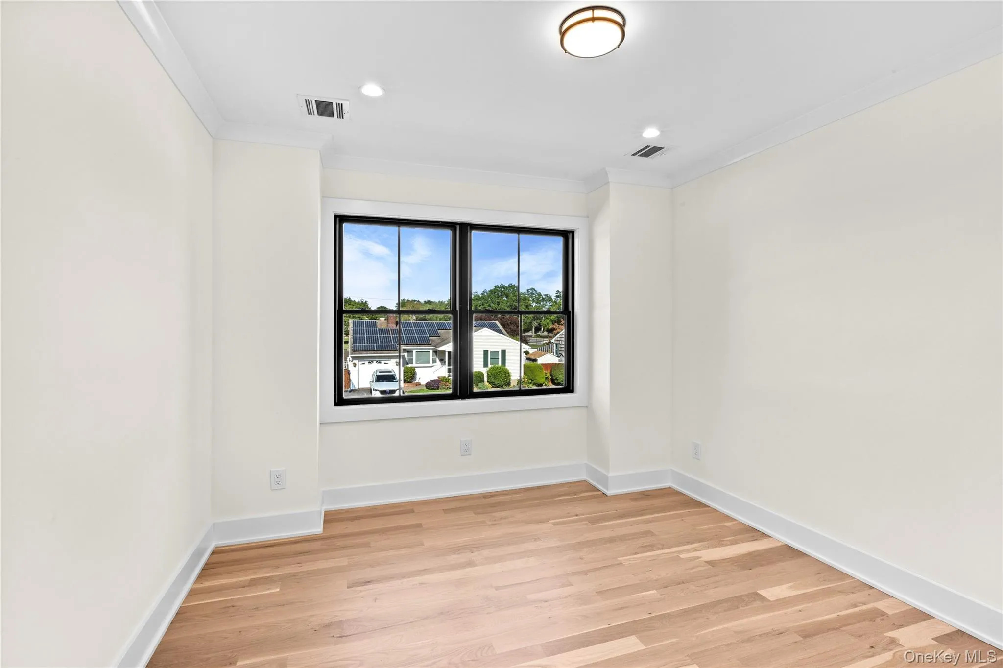 Empty room featuring light wood-style floors, ornamental molding, and recessed lighting Empty room featuring light wood-style floors, ornamental molding, and recessed lighting