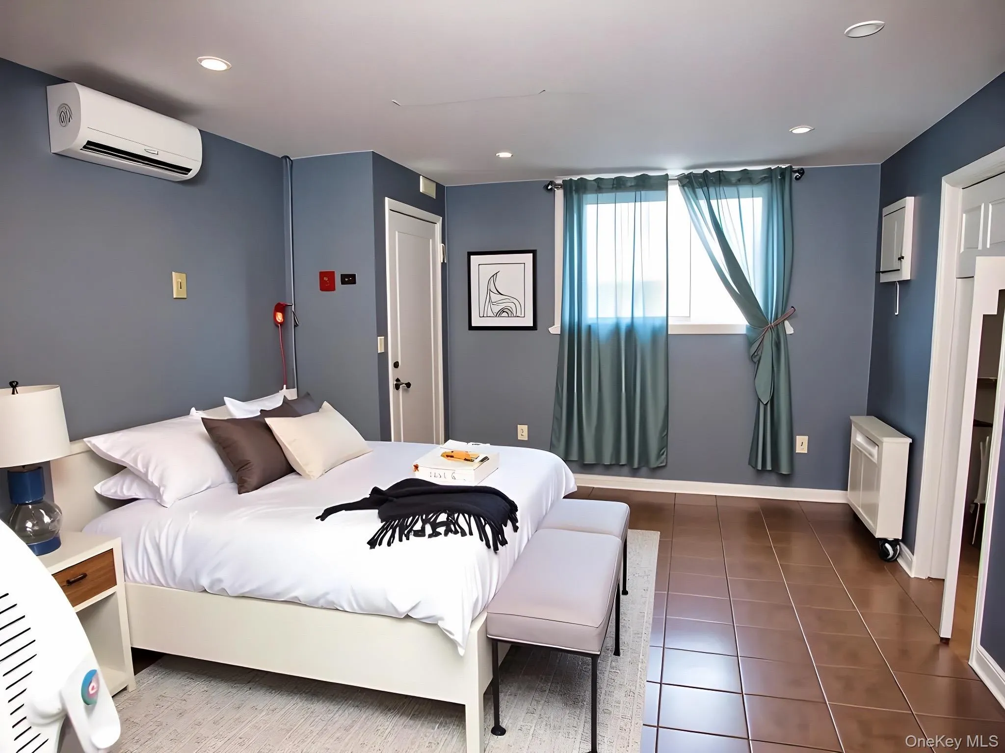 Bedroom featuring dark tile patterned floors, radiator heating unit, recessed lighting, and a wall mounted AC Bedroom featuring dark tile patterned floors, radiator heating unit, recessed lighting, and a wall mounted AC