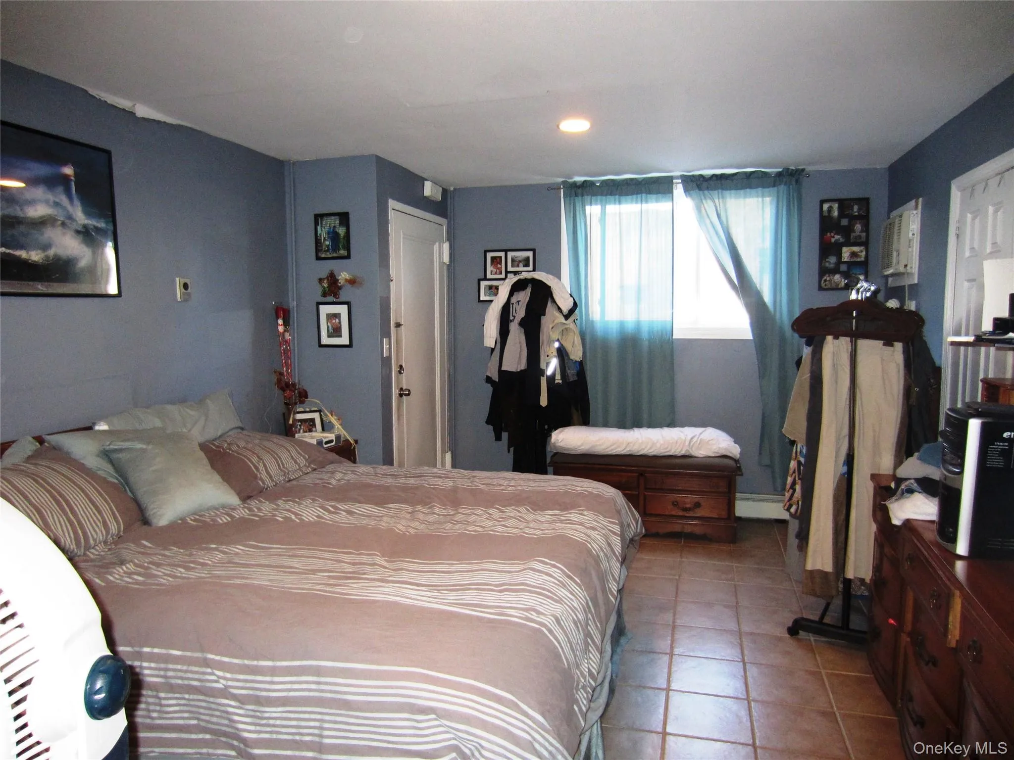 Bedroom with tile patterned floors, recessed lighting, and a baseboard heating unit Bedroom with tile patterned floors, recessed lighting, and a baseboard heating unit