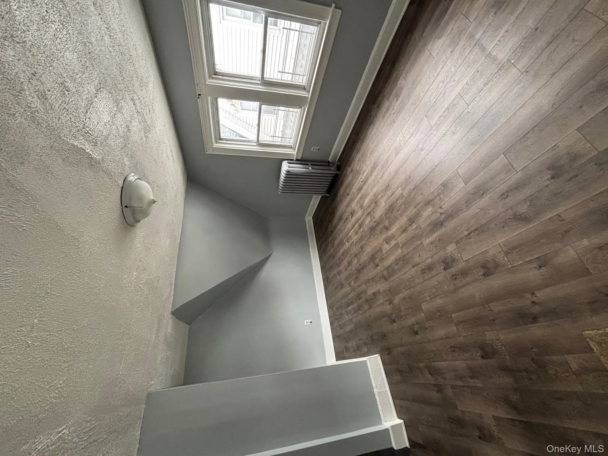 Additional living space with radiator, a textured ceiling, dark wood finished floors, and vaulted ceiling Additional living space with radiator, a textured ceiling, dark wood finished floors, and vaulted ceiling