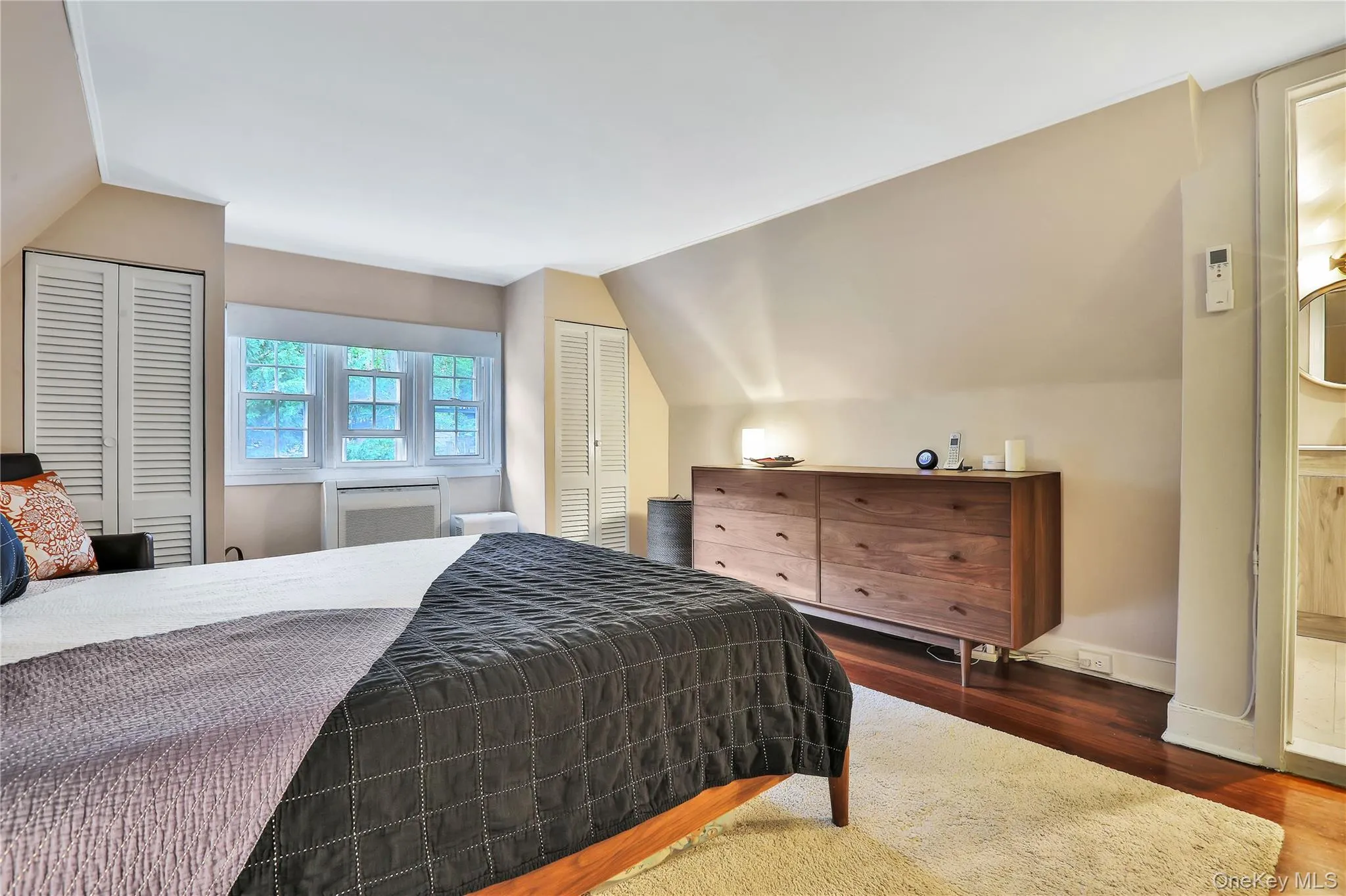 Bedroom featuring vaulted ceiling, closets, and hardwood floors Bedroom featuring vaulted ceiling, closets, and hardwood floors