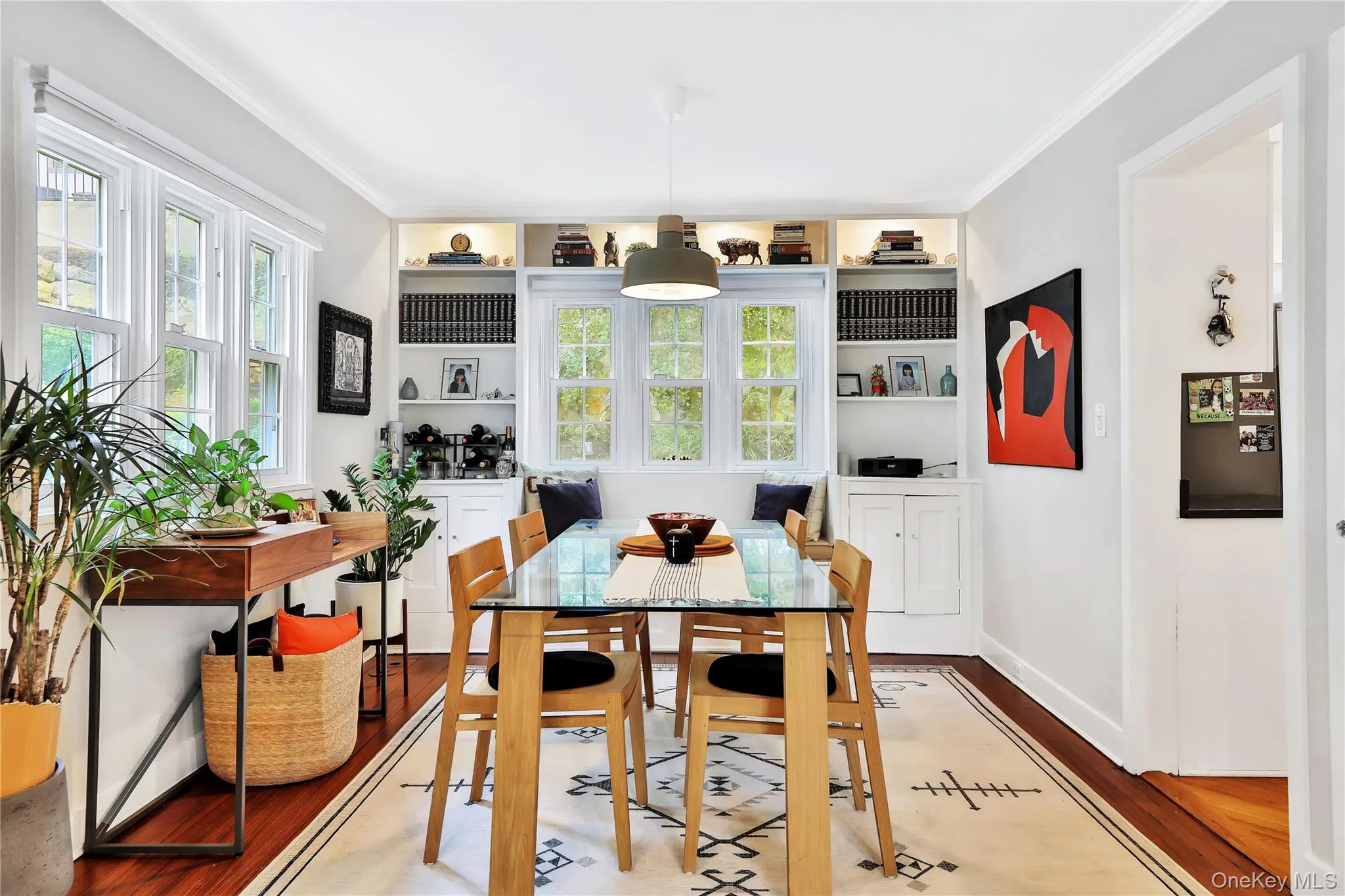 Dining space featuring ornamental molding, hardwood floors, and healthy amount of natural light Dining space featuring ornamental molding, hardwood floors, and healthy amount of natural light