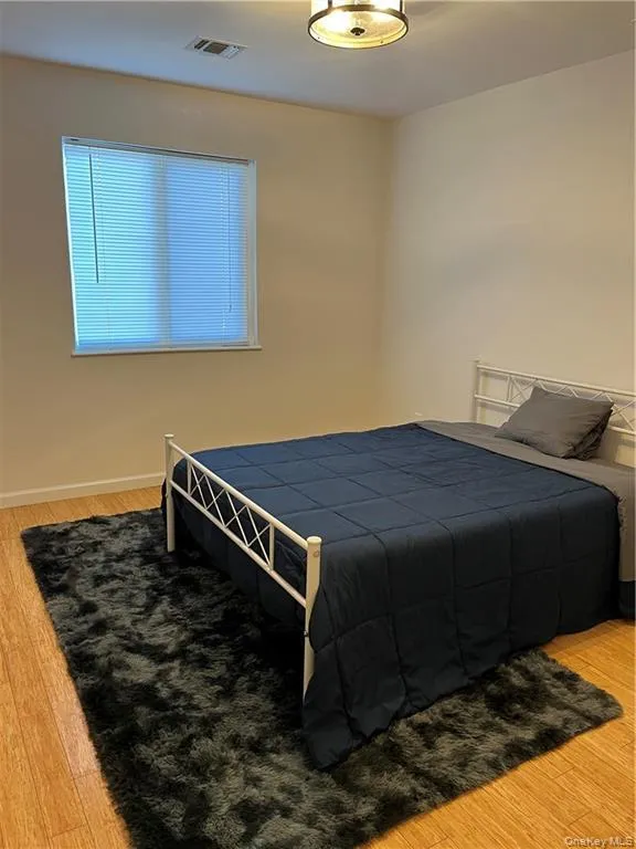 Bedroom featuring light wood-style flooring and baseboards Bedroom featuring light wood-style flooring and baseboards