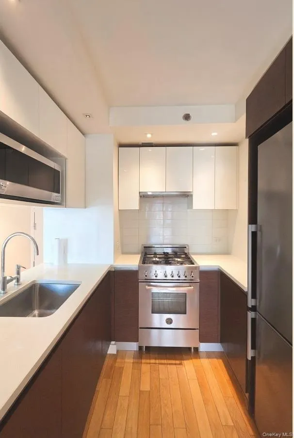 Kitchen featuring stainless steel appliances, white cabinets, modern cabinets, decorative backsplash, and recessed lighting Kitchen featuring stainless steel appliances, white cabinets, modern cabinets, decorative backsplash, and recessed lighting