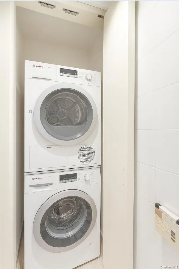 Laundry room with stacked washing machine and dryer Laundry room with stacked washing machine and dryer