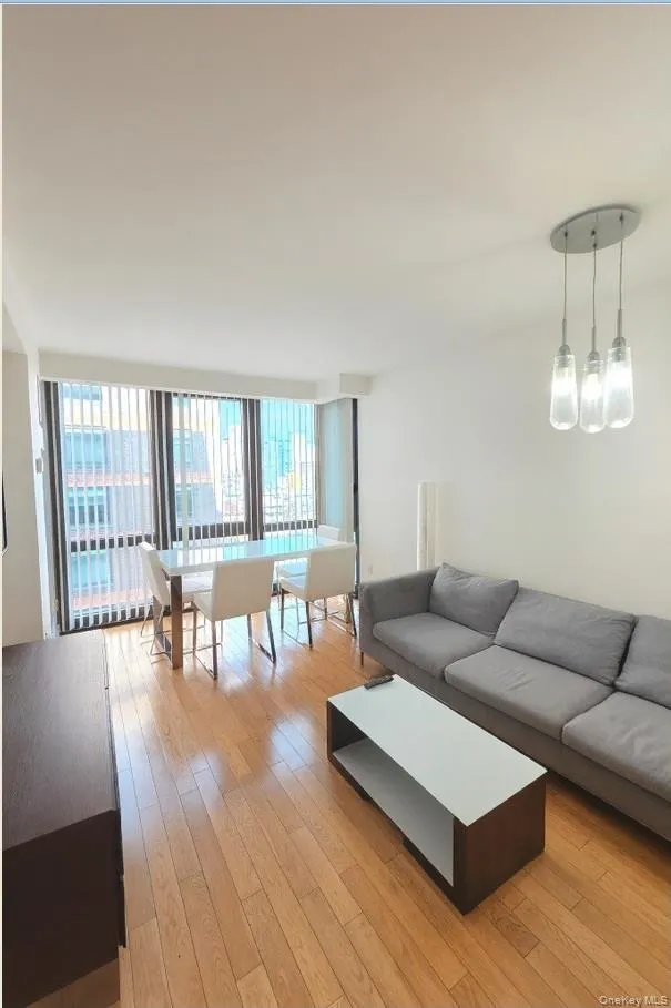 Living room featuring a wall of windows and light wood finished floors Living room featuring a wall of windows and light wood finished floors