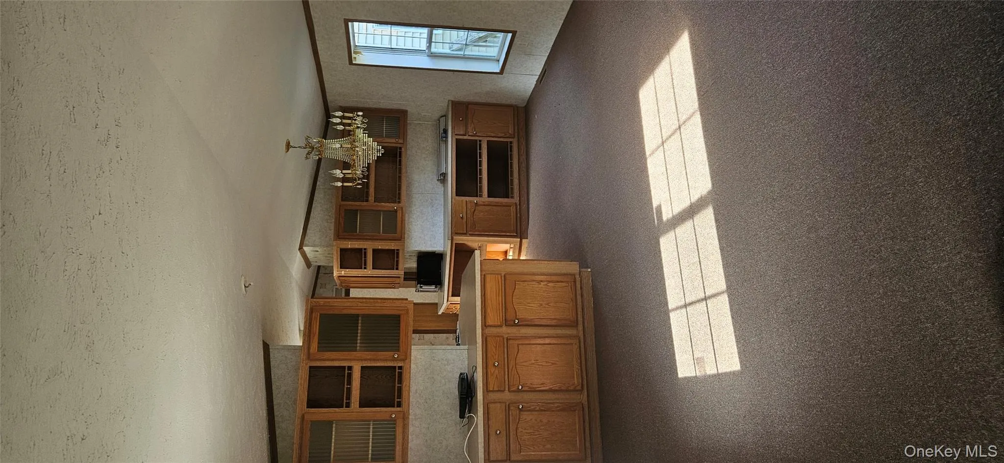 Kitchen with brown cabinets, light countertops, and open shelves Kitchen with brown cabinets, light countertops, and open shelves