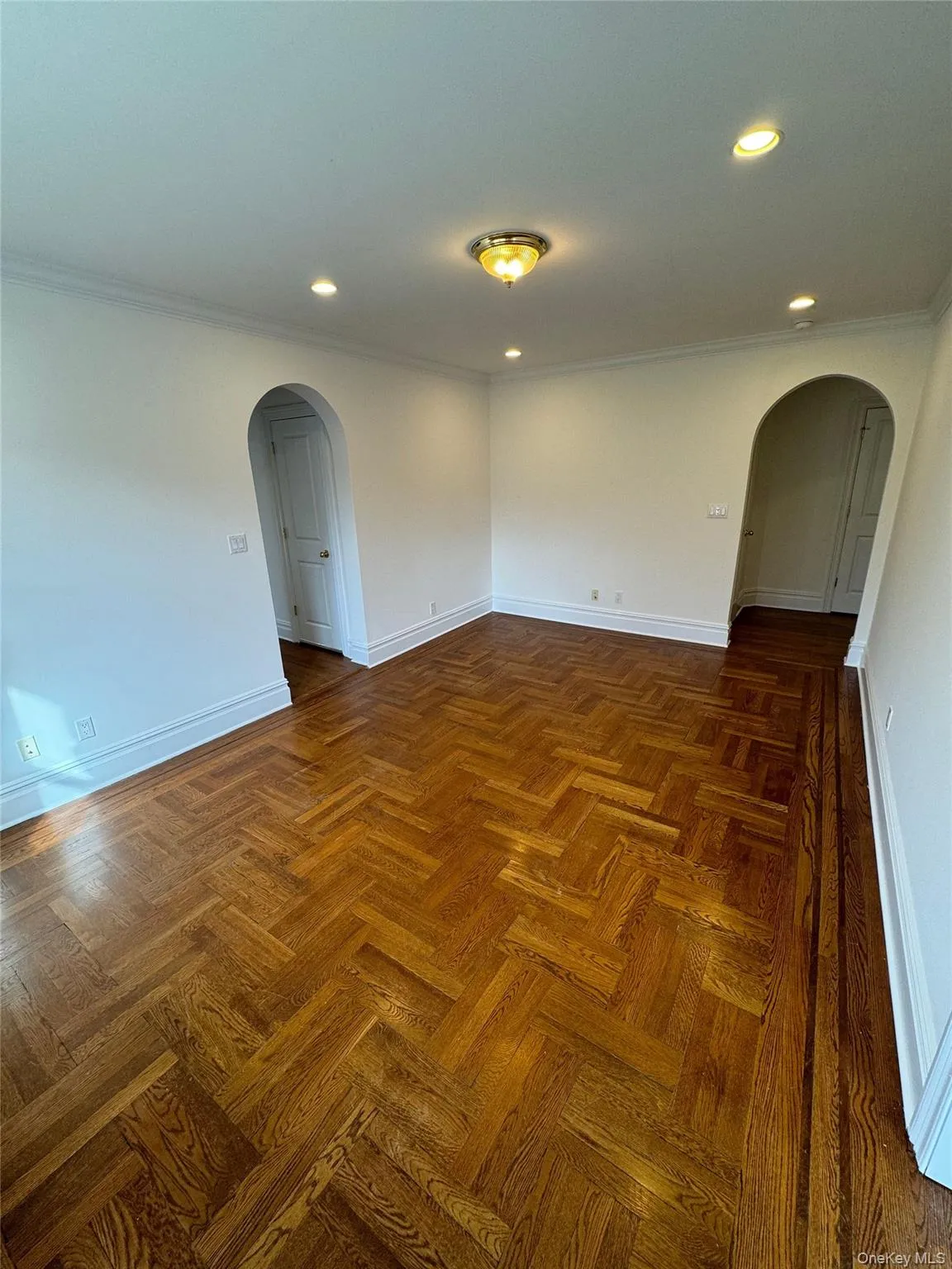 Unfurnished room with arched walkways, crown molding, and recessed lighting Unfurnished room with arched walkways, crown molding, and recessed lighting