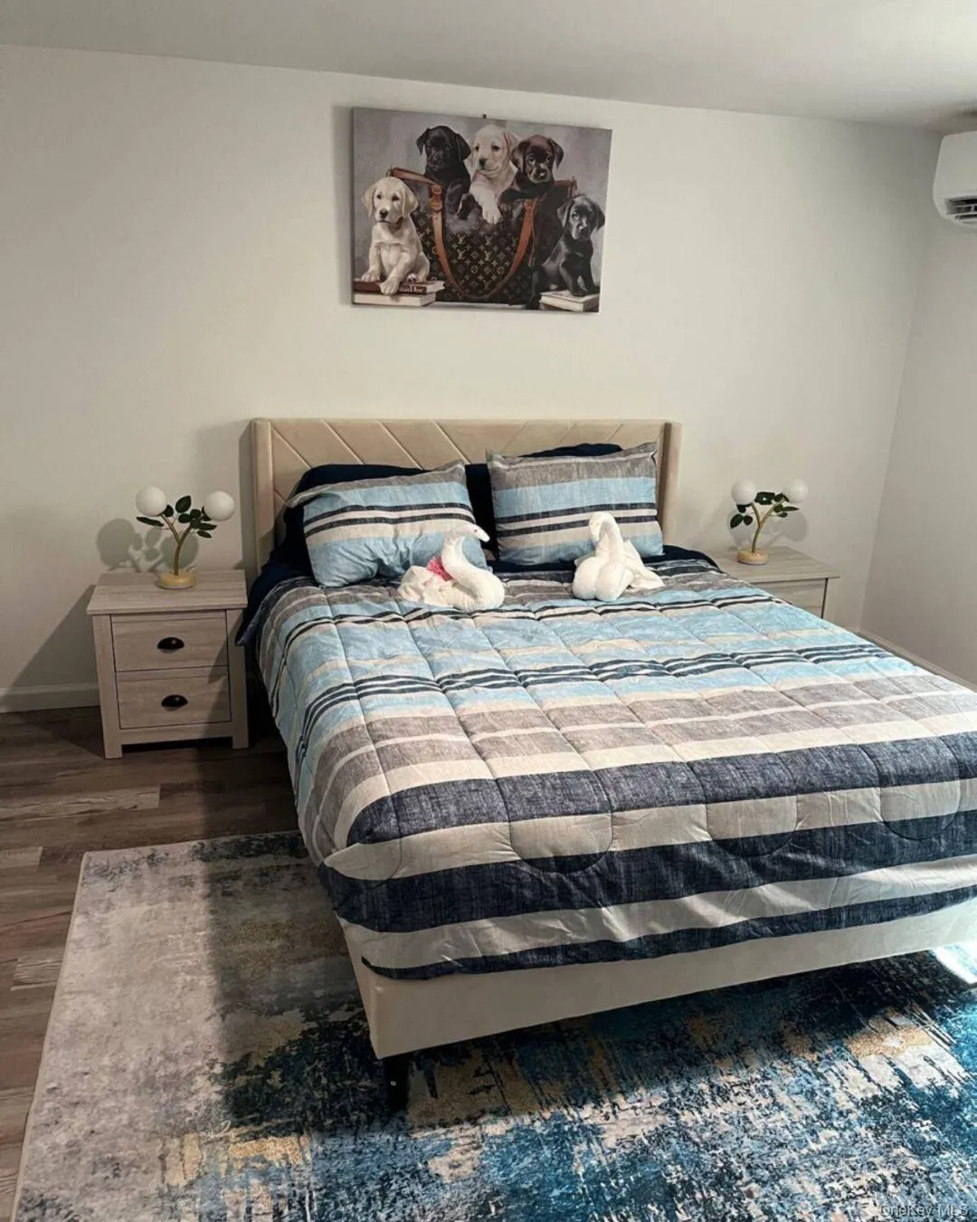 Bedroom featuring wood finished floors and a wall unit AC Bedroom featuring wood finished floors and a wall unit AC