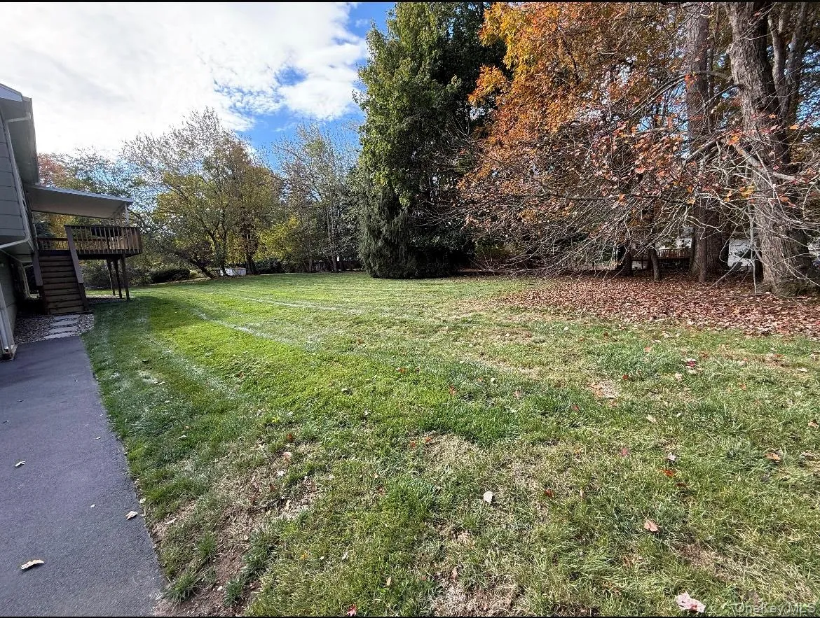View of grassy yard with a wooden deck View of grassy yard with a wooden deck