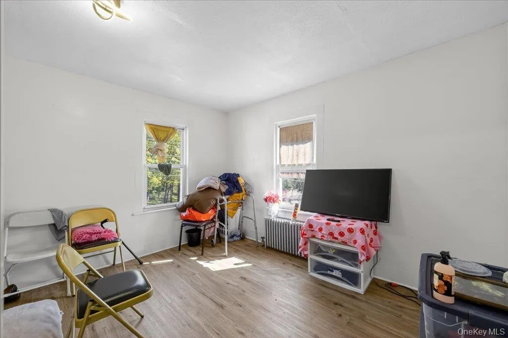 Recreation room with wood finished floors, plenty of natural light, and radiator heating unit Recreation room with wood finished floors, plenty of natural light, and radiator heating unit