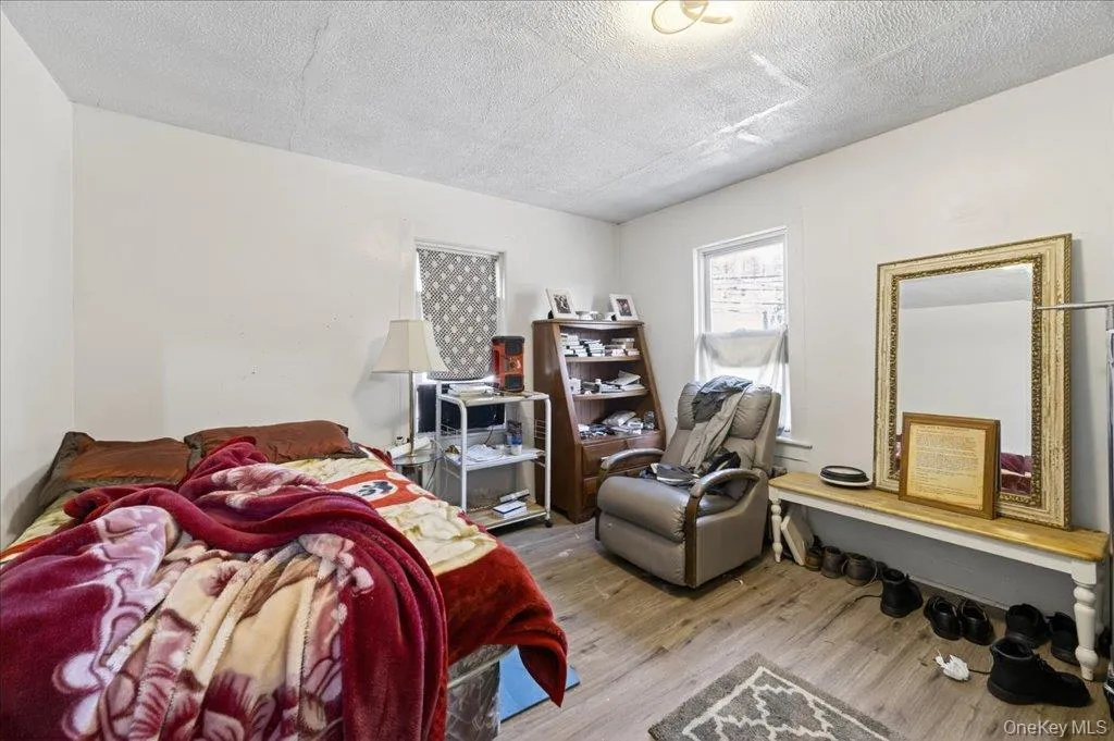 Bedroom featuring wood finished floors and a textured ceiling Bedroom featuring wood finished floors and a textured ceiling