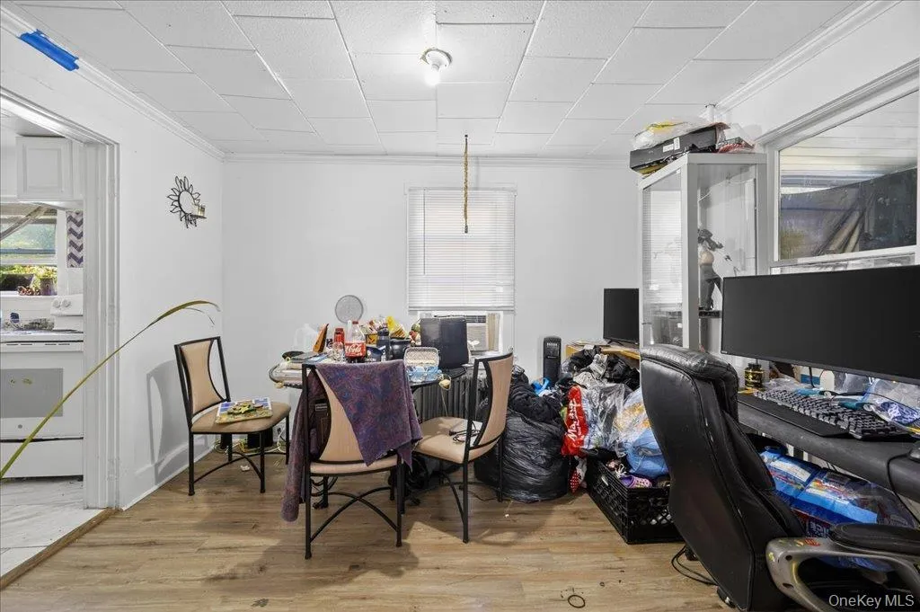 Office space with ornamental molding, light wood-type flooring, and a paneled ceiling Office space with ornamental molding, light wood-type flooring, and a paneled ceiling