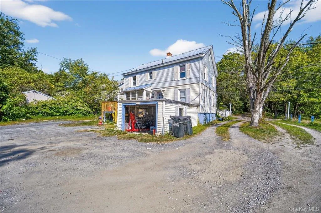 Back of property featuring a chimney and driveway Back of property featuring a chimney and driveway