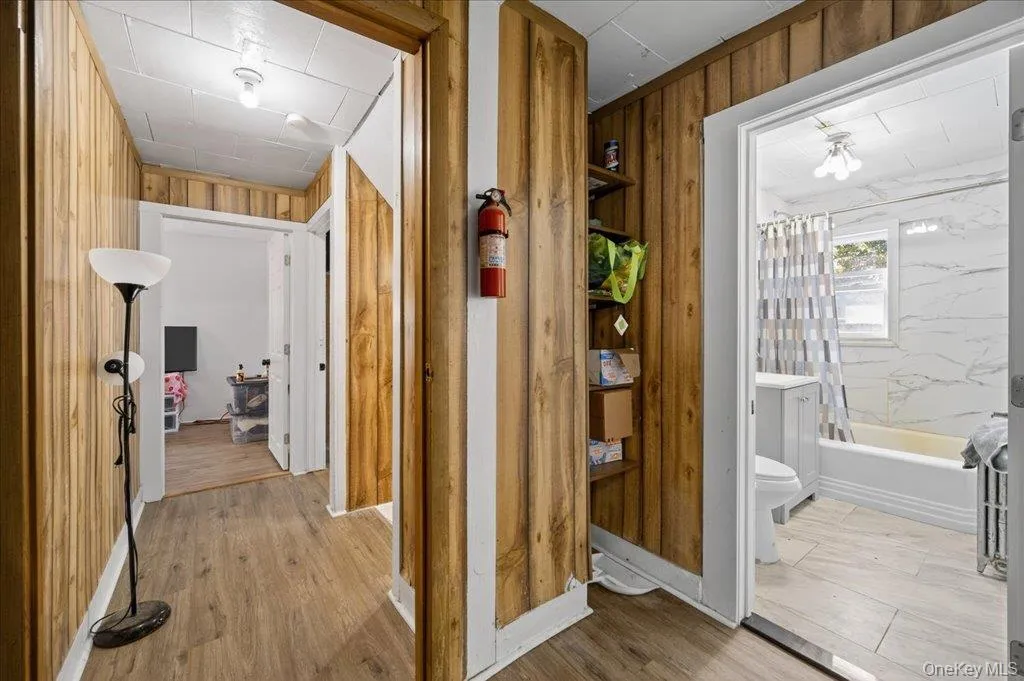 Hall with light wood finished floors and wood walls Hall with light wood finished floors and wood walls