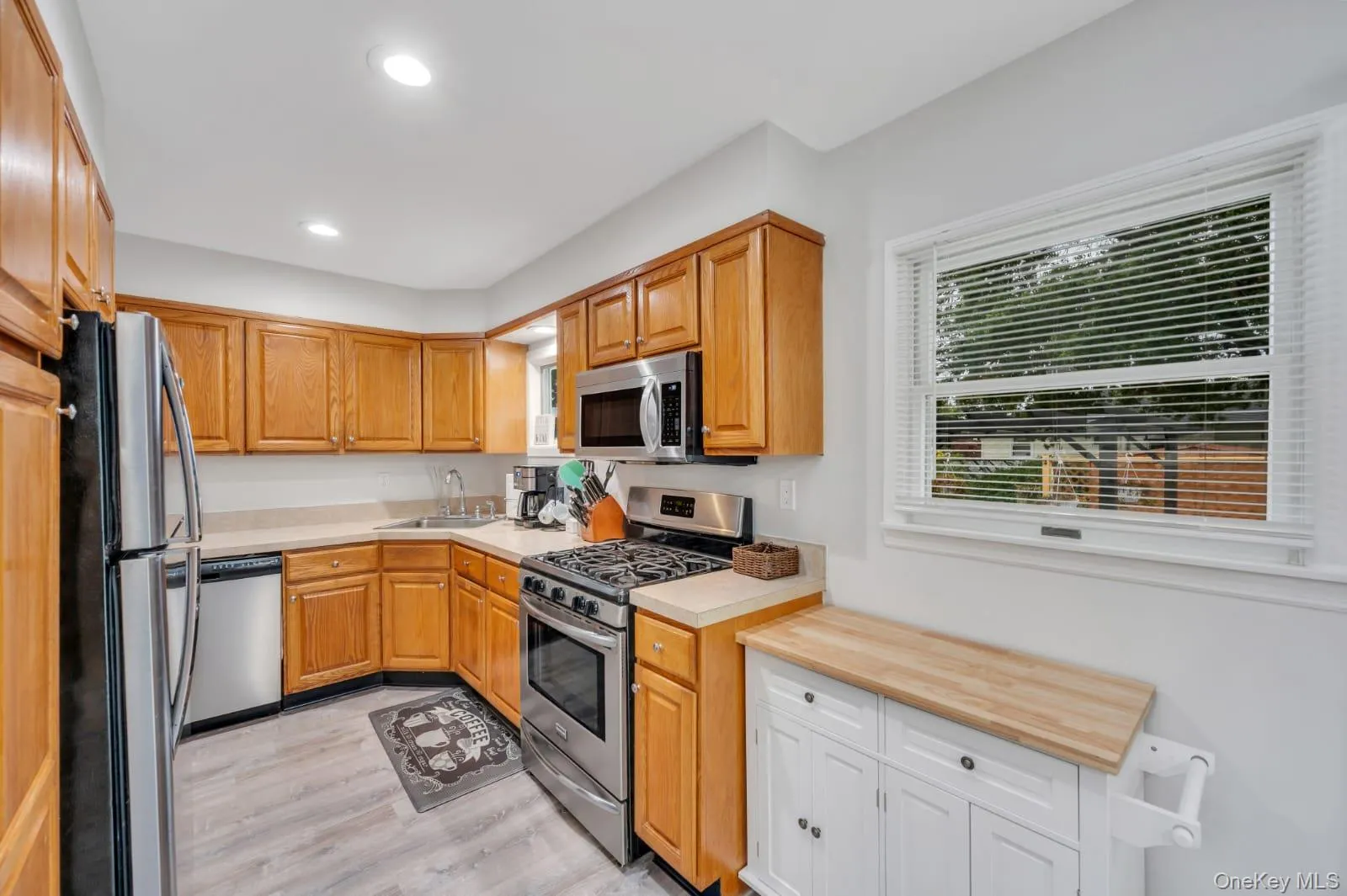Kitchen featuring stainless steel appliances, recessed lighting, light wood-style floors, and wooden counters Kitchen featuring stainless steel appliances, recessed lighting, light wood-style floors, and wooden counters