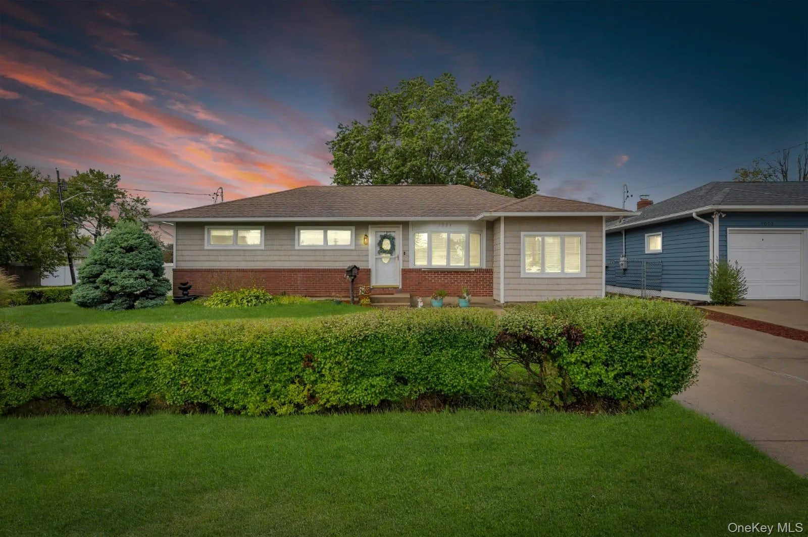 Ranch-style house with a front lawn, a garage, driveway, a shingled roof, and brick siding Ranch-style house with a front lawn, a garage, driveway, a shingled roof, and brick siding